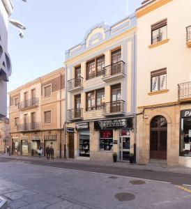 una strada cittadina vuota con edifici e persone che camminano di Apartamentos Pozo Amarillo a Salamanca