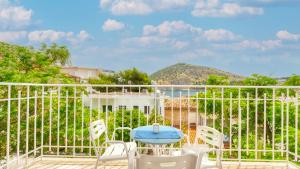 a balcony with a blue table and white chairs at Akrotopi Apartments & Studios in Tolo