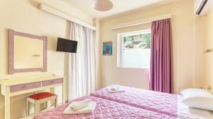 Postel nebo postele na pokoji v ubytování Akrotopi Apartments & Studios