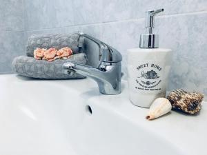 a bathroom sink with a faucet and a soap bottle at Voce Del Mare - sea view- Alghero Airport in Alghero