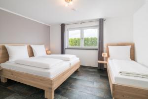 two beds in a room with a window at Apartmenthaus Aulendorf in Aulendorf