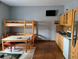 モーラハロムにあるAmina Apartmanのテーブルと二段ベッドが備わる客室です。