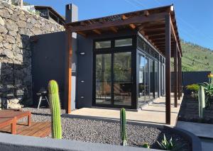 a house with glass doors and cactuses in a yard at CANARIO in Las Indias