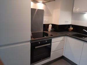 a kitchen with white cabinets and a black stove top oven at Park Horizon in Sainte-Maxime