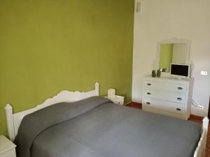 - une chambre avec un lit, une commode et un miroir dans l'établissement B&B La Scapola, à Mattinata