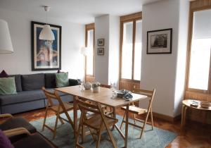 uma sala de estar com uma mesa e cadeiras e um sofá em The David Hume Residence em Edimburgo