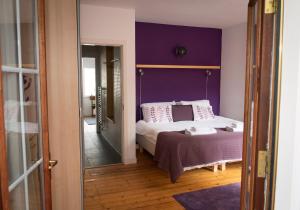 a bedroom with a bed with a purple wall at The David Hume Residence in Edinburgh