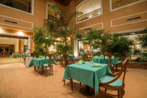 a restaurant with green tables and chairs and plants at Imperial Shams Abu Soma in Hurghada