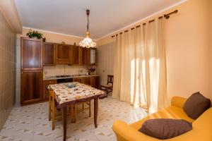 a living room with a table and a kitchen at Case Maria in Castellammare del Golfo