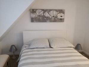 a bedroom with a bed with a picture on the wall at La Citadelle charme et authenticité in Lorgues