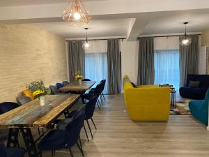 a dining room with tables and yellow chairs at Casa Skadi, Zamora,Busteni in Buşteni