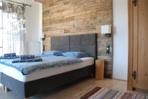 een slaapkamer met een bed met een houten muur bij U Kapiarza in Klikuszowa