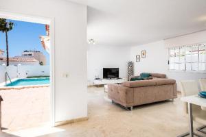 a white living room with a couch and a tv at Casa Virgo in Adeje