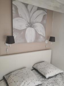 a bedroom with a bed with a flower picture on the wall at La Citadelle charme et authenticité in Lorgues