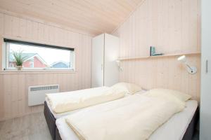 - une chambre avec 2 lits dans une chambre avec une fenêtre dans l'établissement Resort 2 Ocean Cottage A 87, à Großenbrode