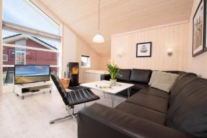 a living room with a black couch and a tv at Resort 2 Sea Lodge C 65 in Großenbrode
