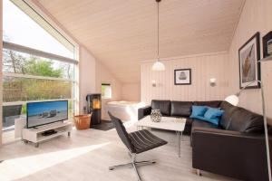 een woonkamer met een bank en een tv bij Resort 2 Ocean Cottage A 16 in Großenbrode