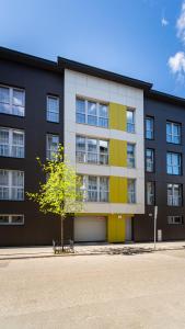 un edificio con un árbol delante de él en Apartamenty na Chrobrego, en Bydgoszcz