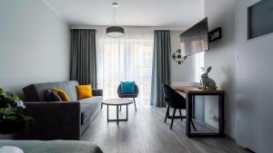 una sala de estar con un sofá y una mesa en Apartamenty na Chrobrego, en Bydgoszcz