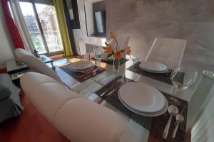 a dining room table with white chairs and a glass table at Piso céntrico con piscina,parking y jacuzzi in Córdoba