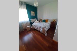 una camera da letto con un letto e un pavimento in legno di Piso céntrico con piscina,parking y jacuzzi a Cordoba