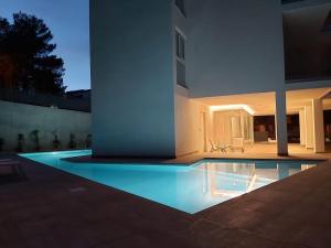 uma piscina em frente a uma casa à noite em Apartment Formentor with sea view, pool & terrace in Canyamel em Canyamel
