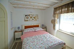 1 dormitorio con 1 cama con edredón rosa y ventana en Apartment SANJIN MORE ANTIQUE, en Baška