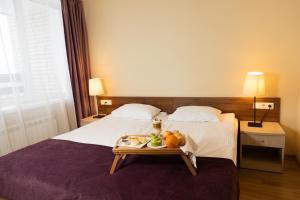 ein Hotelzimmer mit einem Bett und einem Tablett mit Obst darauf in der Unterkunft Repinskaya Hotel in Repino