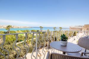 einen Balkon mit einem Tisch, Stühlen und Meerblick in der Unterkunft Hotel Bellavista - Boutique Hotel in Otranto