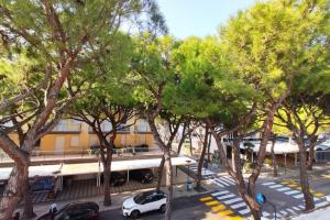 a street with cars parked in front of a building at DELTA D Piazza Marina- 50 MT dal mare - Immobil Relax in Lido di Jesolo