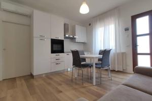 a kitchen and dining room with a table and chairs at DELTA D Piazza Marina- 50 MT dal mare - Immobil Relax in Lido di Jesolo