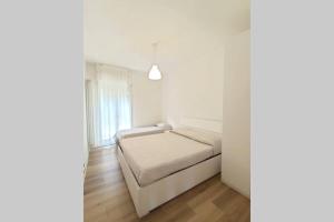 a white bedroom with a bed and a window at DELTA D Piazza Marina- 50 MT dal mare - Immobil Relax in Lido di Jesolo