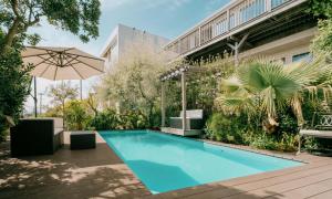 a swimming pool with an umbrella next to a building at Kamakura Private Pool & Sauna Villa - Casablanca Pool House in Kamakura