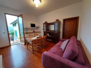 ein Wohnzimmer mit einem lila Sofa und einem Tisch in der Unterkunft Gli Oleandri B&B in Vaiano