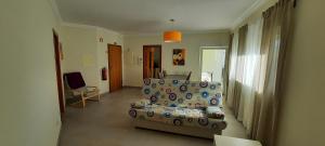 a living room with a couch and a chair at Apartamentos Pátio da Aldeia in Armação de Pêra