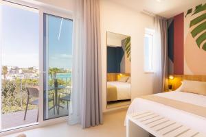a bedroom with a bed and a view of the ocean at Hotel Bellavista - Boutique Hotel in Otranto