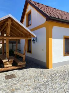 un pequeño edificio blanco con techo y patio en Gästehaus Fischer Rohrendorf, en Rohrendorf bei Krems