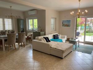 a living room with a couch and a dining room at Villa Scamard in Zamárdi