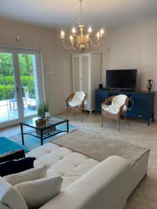 uma sala de estar com um sofá e uma televisão em Villa Scamard em Zamárdi