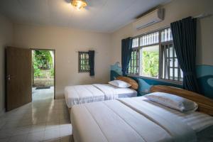 a hotel room with two beds and a window at Endless Summer Surf Camp Kuta in Kuta +55 photos