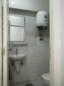 uma casa de banho branca com um lavatório e um WC em 1B V150B Chalet 3bedrooms basement green beach em El Alamein
