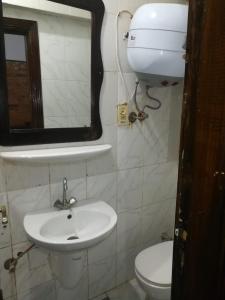 uma casa de banho com um lavatório, um WC e um espelho. em 1B V150B Chalet 3bedrooms basement green beach em El Alamein