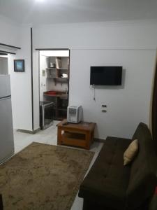 uma sala de estar com um sofá e uma televisão na parede em 1B V150B Chalet 3bedrooms basement green beach em El Alamein