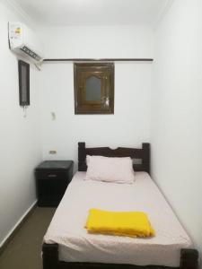 um quarto com uma cama com um cobertor amarelo em 1B V150B Chalet 3bedrooms basement green beach em El Alamein