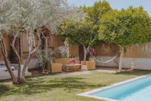 a backyard with a hammock and trees and a pool at Tagadert Lodge in Oumnas