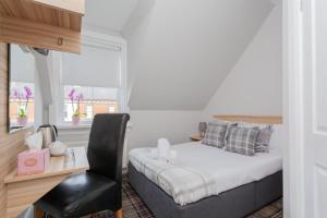 a bedroom with a bed and a desk and a chair at Botanic Rest Queens Quarter in Belfast