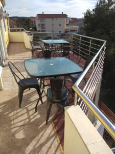 patio ze stołami i krzesłami na balkonie w obiekcie Apartments Ankica w Szybeniku
