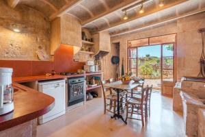 a kitchen with a table and chairs in a room at Son Sunyer in La Aranjasa