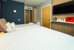 a bedroom with a large white bed and a flat screen tv at Holiday Inn Express Ramsgate – Minster by IHG in Minster