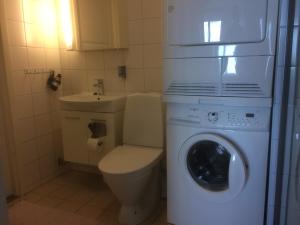 a bathroom with a washing machine and a sink at Snäck Apartment floor 11 sea view in Visby